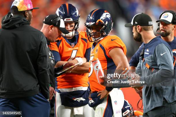 Russell Wilson and head coach Nathaniel Hackett of the Denver Broncos talk during a timeout in the game against the Indianapolis Colts at Empower...