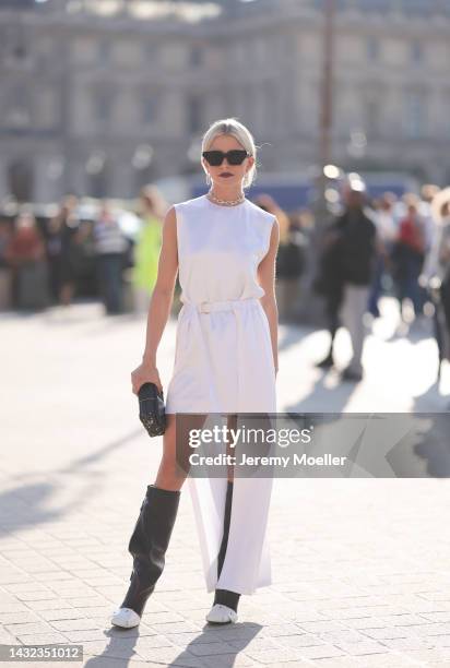 Caro Daur seen wearing black Louis Vuitton leather boots, shades by Louis Vuitton, a Louis Vuitton leather clutch and a white vokuhila dress by Louis...