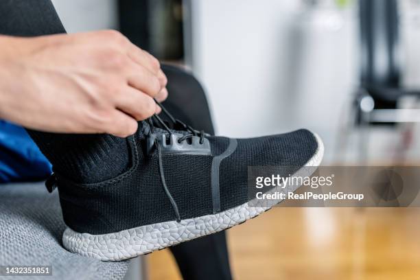 man tying shoelaces on the black sports shoe - black shoe 個照片及圖片檔