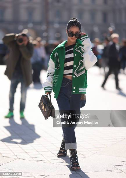 Ann seen wearing an oversized college jacket by Louis Vuitton, a Louis Vuitton brown leather bag, jeans and polka dots boots by Louis Vuitton,...