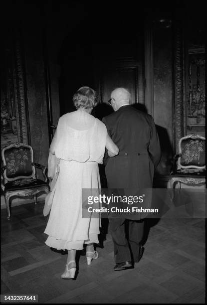 View, from behind, of married couple, Alma Wassermann and Polish-born American author Isaac Bashevis Singer as they leave a ball, where Singer had...