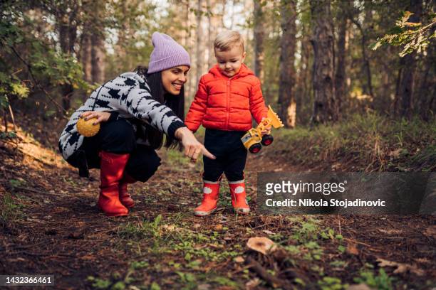 mamá e hijo en el bosque - fond orange fotografías e imágenes de stock