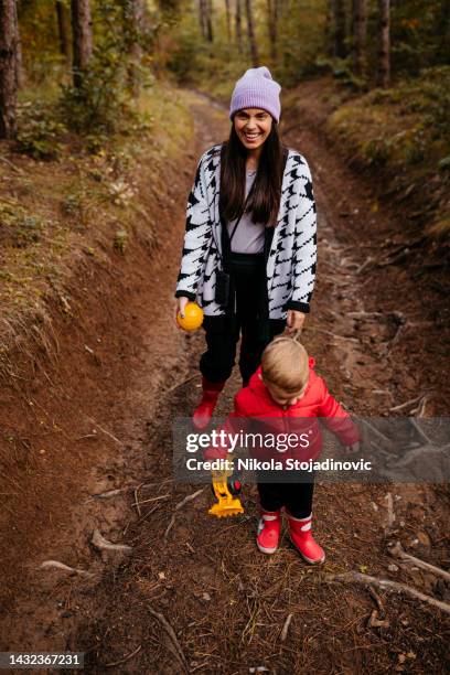 exploring the nature together - woman picking up toys stock pictures, royalty-free photos & images