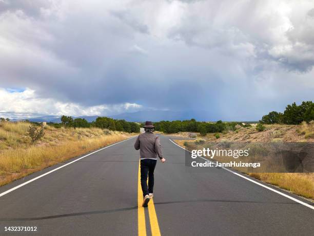 man running on double yellow line on country road - person escaping stock pictures, royalty-free photos & images