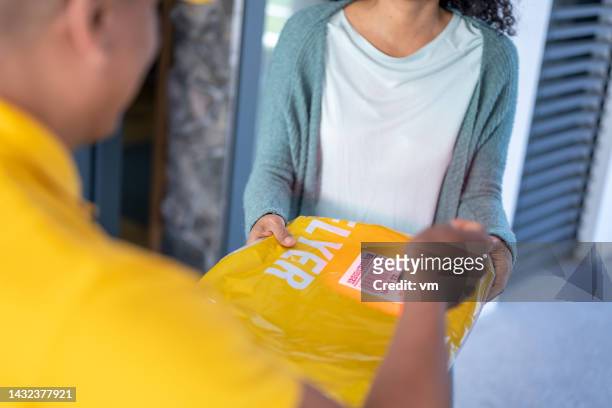 customer getting package from courier, home delivery service - answering door stock pictures, royalty-free photos & images