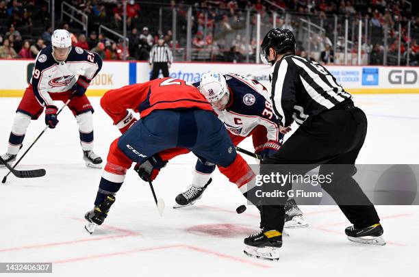 Boone Jenner of the Columbus Blue Jackets takes a face-off against Nic Dowd of the Washington Capitals during a preseason game at Capital One Arena...