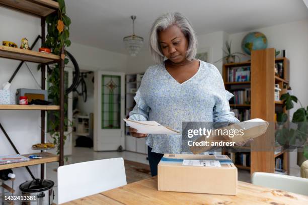 woman at home getting packages and letters in the mail - elderly receiving paperwork stock pictures, royalty-free photos & images