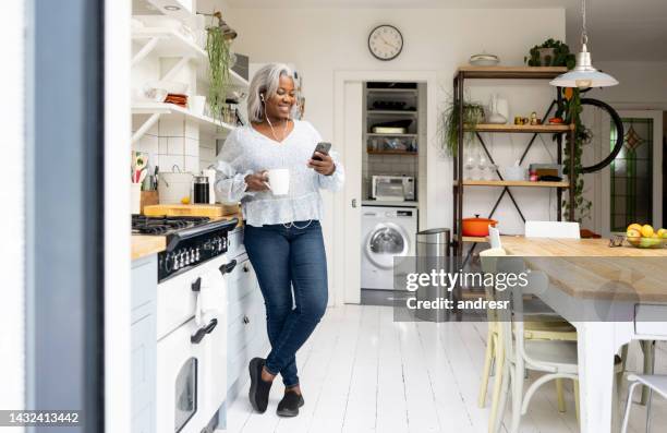 woman at home watching videos on her cell phone - one woman only videos stock pictures, royalty-free photos & images