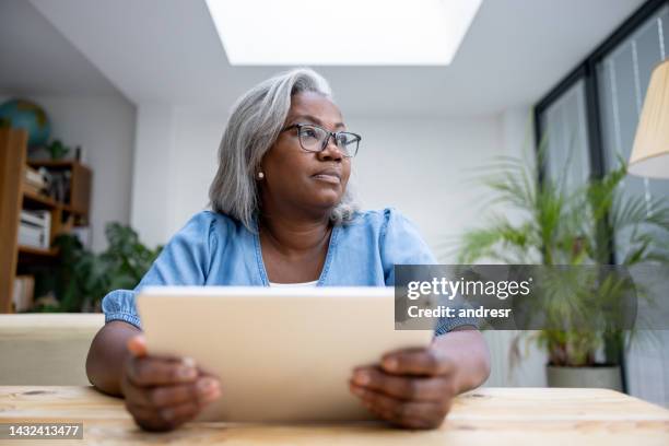 mature woman at home reading on her tablet - reading glasses isolated stock pictures, royalty-free photos & images