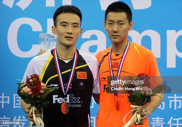 Chen Jin of China poses with Du Pengyu of China after winning the men's singles final during day six of the 2012 Badminton Asia Championships at...