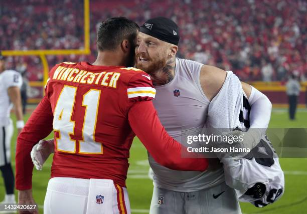 James Winchester of the Kansas City Chiefs and Maxx Crosby of the Las Vegas Raiders hug after the game at Arrowhead Stadium on October 10, 2022 in...