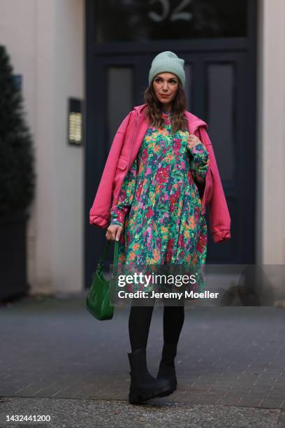 Anna Wolfers wearing a mint-colored knitted hat, pink jacket, colorful long dress, black tights, black boots and a green handbag on October 06, 2022...
