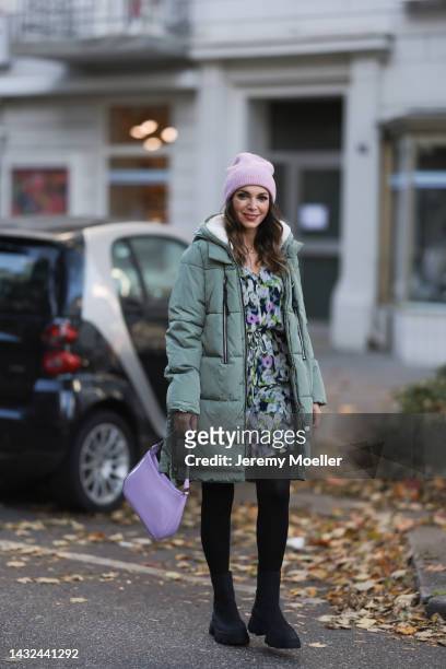 Anna Wolfers wearing a a purple knitted hat, mint jacket, colorful dress, black tights, black boots and a purple handbag on October 06, 2022 in...