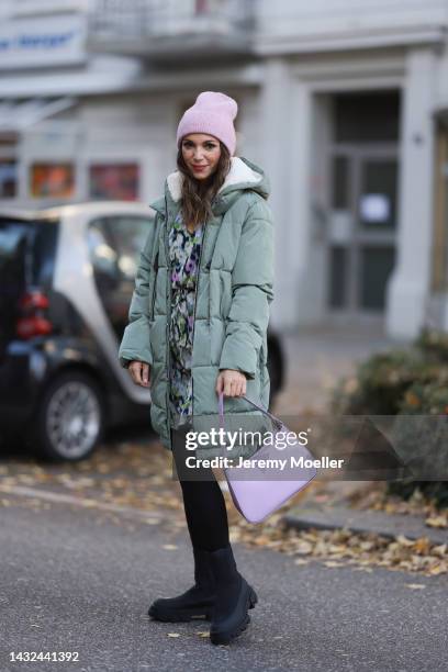 Anna Wolfers wearing a a purple knitted hat, mint jacket, colorful dress, black tights, black boots and a purple handbag on October 06, 2022 in...