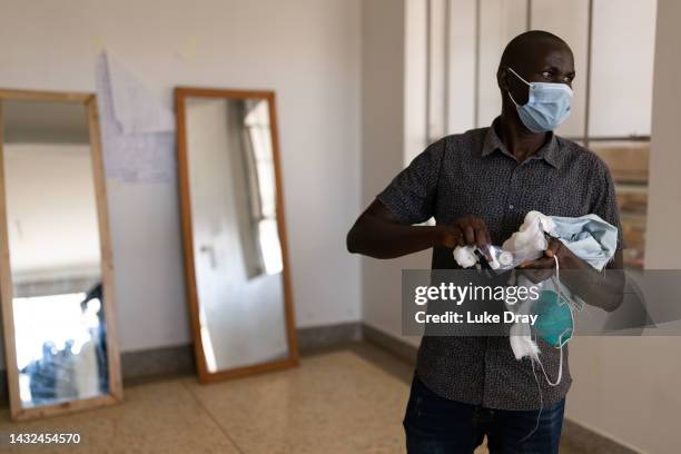 Health worker puts on PPE at the Ebola Treatment Centre in Mubende Regional Referral Hospital on October 10, 2022 in Mubende, Uganda. On October 10,...