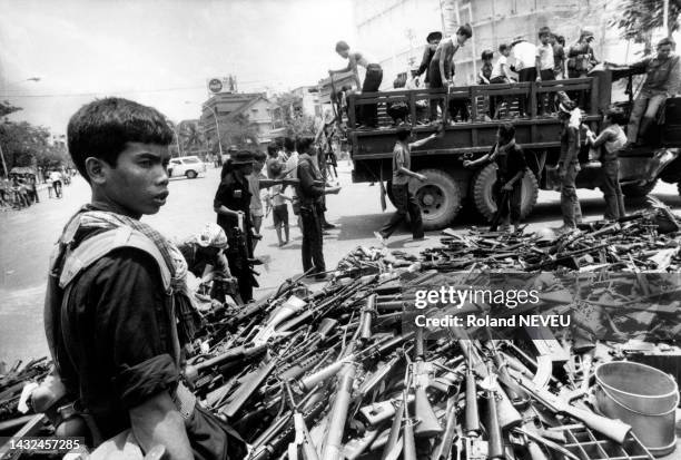 Les habitants de Phnom Penh déposent les armes sous la surveillance des Khmers rouges en avril 1975.