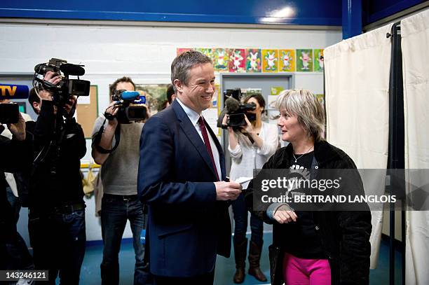The Debout la République party's candidate for the 2012 French presidential election Nicolas Dupont-Aignan stands next to a woman prior to casting...