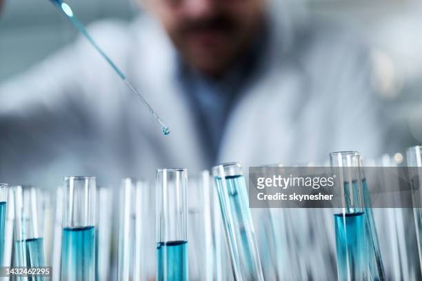 close up of analyzing blue liquid in laboratory. - medicamento antiviral imagens e fotografias de stock