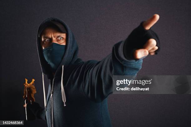 activiste, rebelle, émeute portant un sweat à capuche, une casquette et un masque facial tenant une bouteille à moitié pleine de liquide inflammable connu sous le nom de cocktail molotov prêt à jeter. manifestation de rue violente et concept de chaos - extremism photos et images de collection