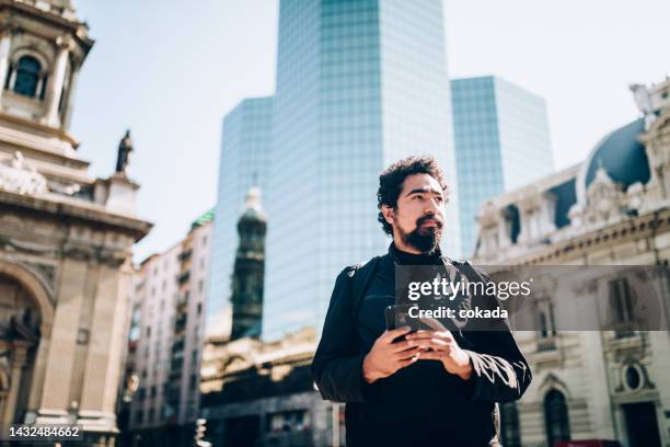man using cell phone at santiago de chile - santiago stock pictures, royalty-free photos & images