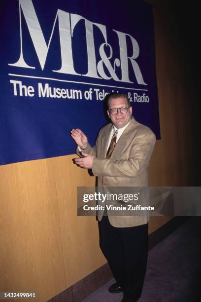 Drew Carey poses next to a sign that reads "MT&R The Museum of Television and Radio" in Los Angeles, United States, cirac 1991.