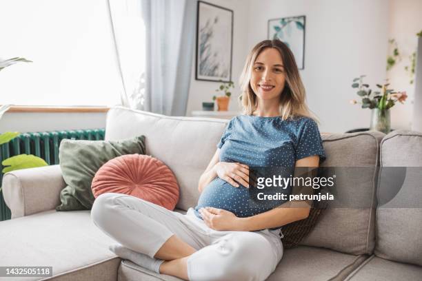 jeune femme enceinte aimant sa grossesse - maternity wear photos et images de collection