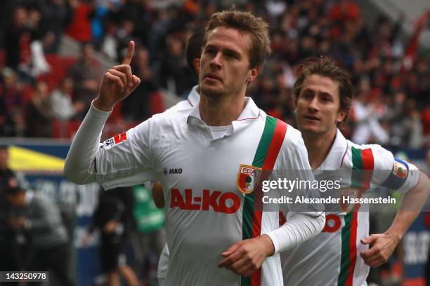 Sebastian Langkamp of Augsburg celebrates scoring the opening goal with his team mate Paul Verhaegh during the Bundesliga match between FC Augsburg...