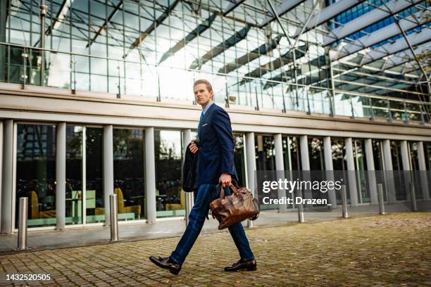 young businessman going to work with leather bag and blue suit - bank manager stock pictures, royalty-free photos & images