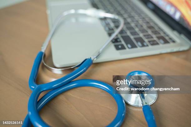 doctor's desk with stethoscope and laptop. - huisarts stockfoto's en -beelden