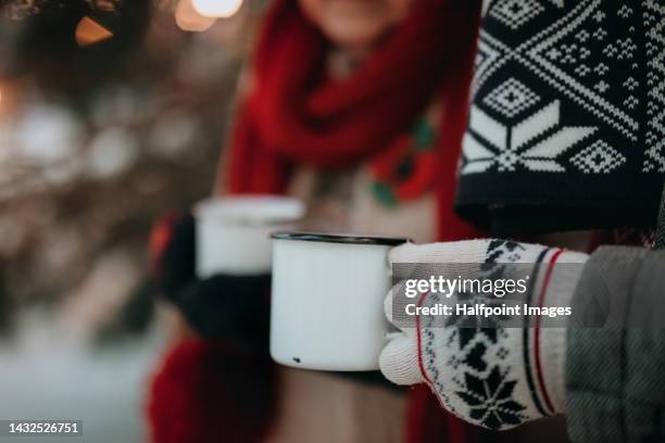 close-up of senior couple holding cups with mulled wine. - glühwein stock-fotos und bilder