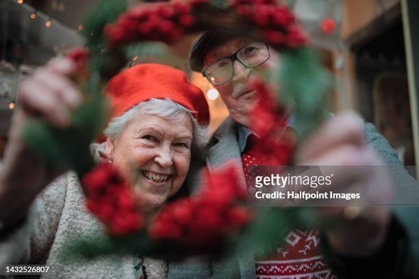 happy senior couple at christmas market. - christmas elderly stock pictures, royalty-free photos & images
