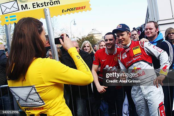 Grid girl takes a photo of Swedish Audi driver Mattias Ekstroem during the DTM touring car presentation on April 22, 2012 in Wiesbaden, Germany.