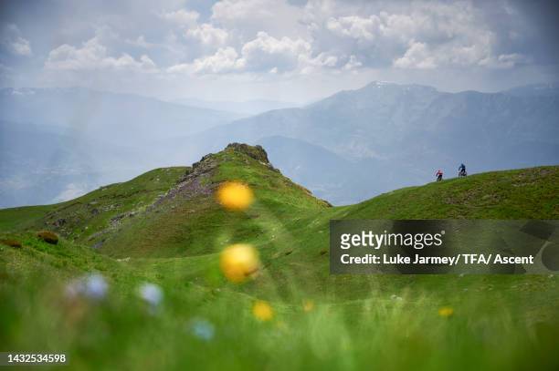 mountain bikers traverse high alpine ridge above stormy mountains - albania stock-fotos und bilder