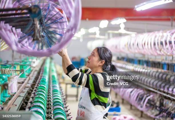 An employee operates a spinning machine at a workshop of Jiangsu Hengyuan Silk Group Co., Ltd on October 11, 2022 in Hai an, Nantong City, Jiangsu...