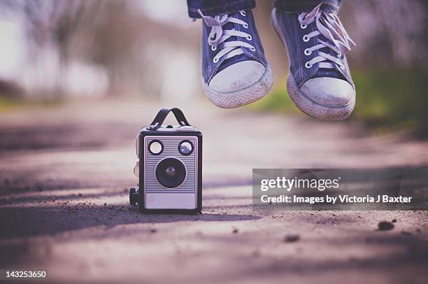 feet jumping next to old box camera - victoria j baxter stock pictures, royalty-free photos & images