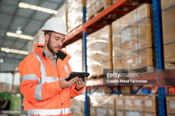 fortify warehouse operations solution with digital twin technology. a male warehouse supervisor uses a tablet computer to review inventory balance and compare it with a checklist to verify a match to the accounting database. - digital twin stock pictures, royalty-free photos & images