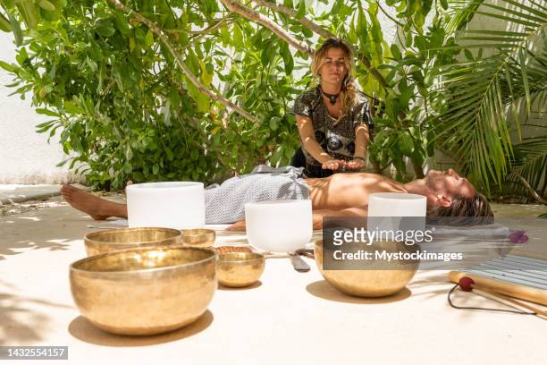 mujer haciendo masaje holístico a los hombres al aire libre - feng shui fotografías e imágenes de stock