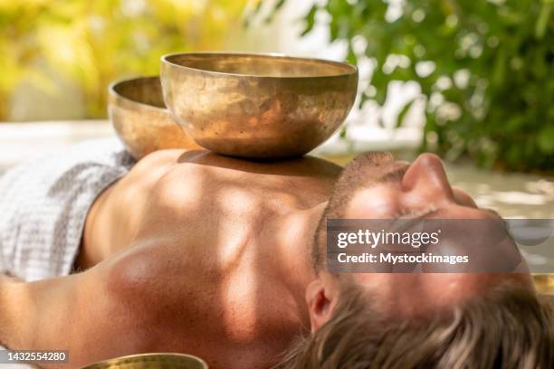 woman doing holistic massage to male outdoors - gong stock pictures, royalty-free photos & images