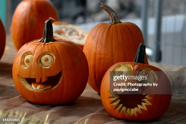 pumpkins decorated with faces with eyes and mouths - jack o' lantern fotografías e imágenes de stock
