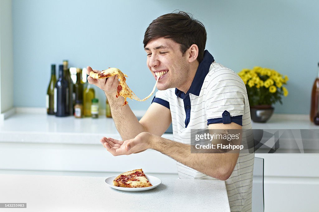 Portrait of man eating pizza