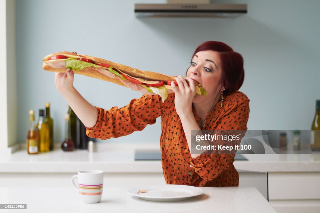 Portrait of woman eating giant baguette