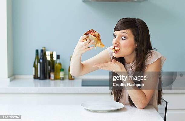 portrait of woman eating pizza - ungesunde ernährung stock-fotos und bilder