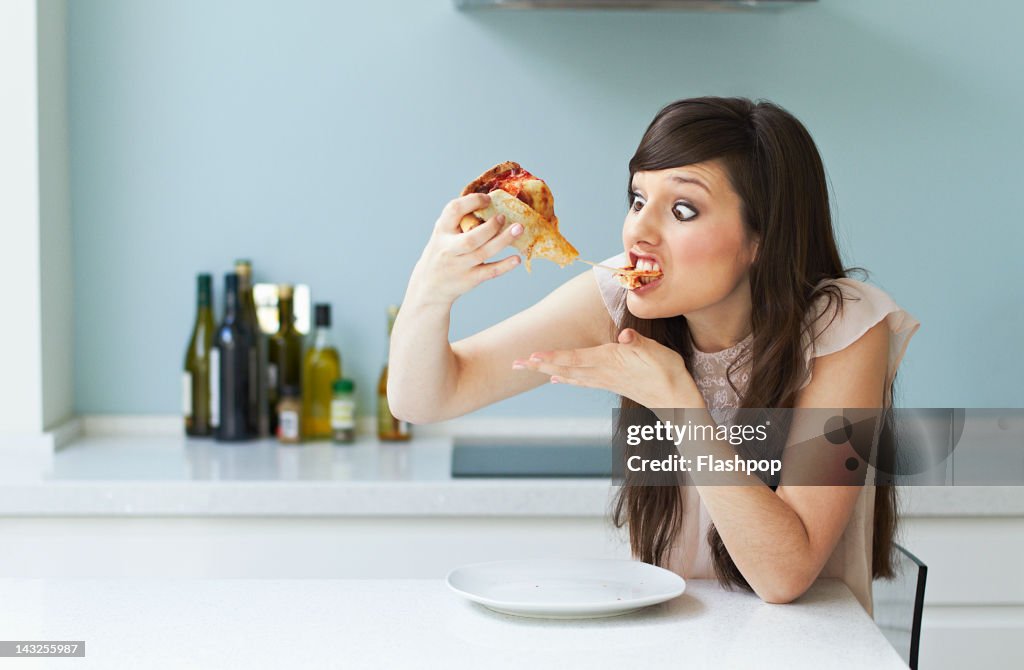 Portrait of woman eating pizza