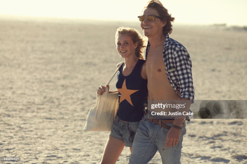 Young couple walking on a beach laughing