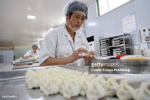 Workers make dumplings known as jiaozi in Chinese at a food processor in Huimin county in east China's Shandong province.