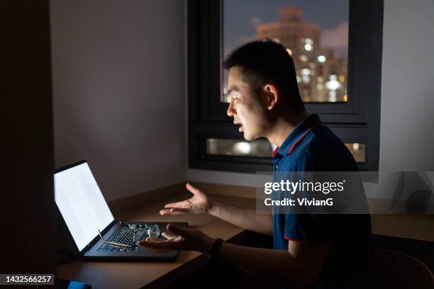 asian man working at home with laptop at night - internet outage stock pictures, royalty-free photos & images