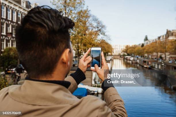 unrecognisable tourist visiting amsterdam and enjoying city break - amsterdam autumn stock pictures, royalty-free photos & images