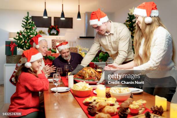 happy family are having dinner at home. celebration holiday and togetherness near tree. holidays, celebration and people concept. - christmas family tree stock-fotos und bilder