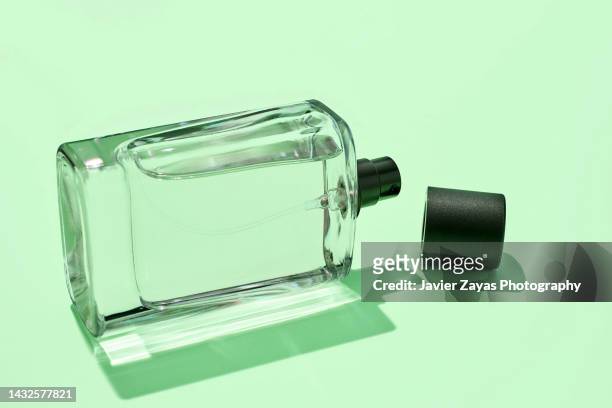 liquid sprayer on green background - aftershave bottle stock-fotos und bilder