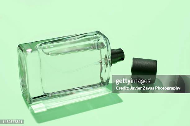 liquid sprayer on green background - cologne bottle stock pictures, royalty-free photos & images